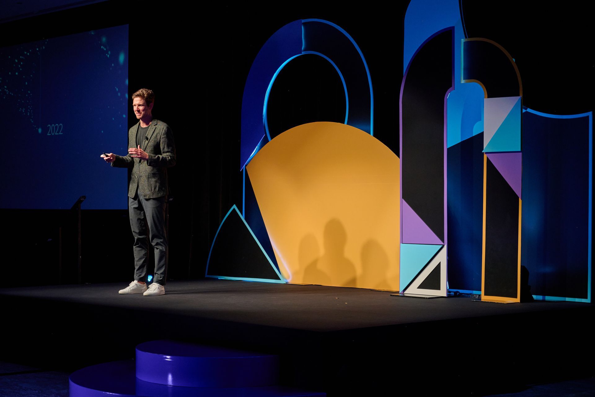 A man is standing on a stage giving a presentation.