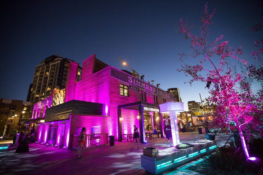 A large building is lit up with purple lights at night.