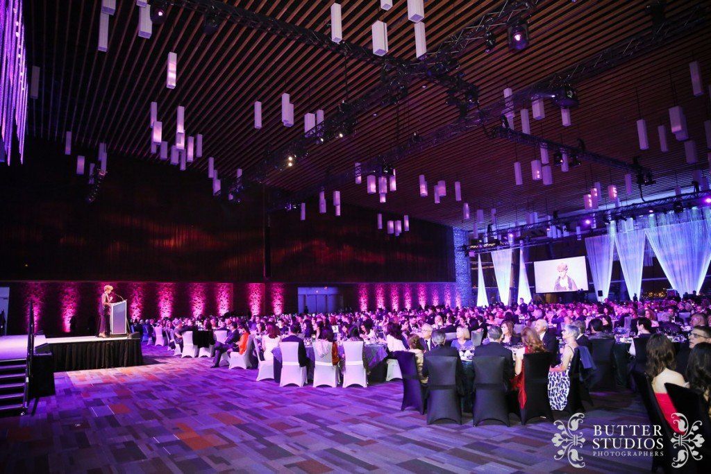 A large room filled with people sitting at tables and chairs.