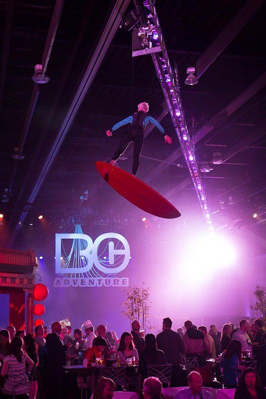 A man is flying through the air on a surfboard.
