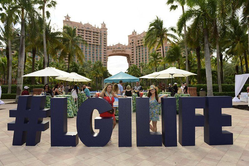 A group of people standing in front of a sign that says #lgilife