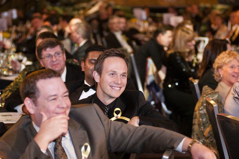 A group of people are sitting at a table and smiling.
