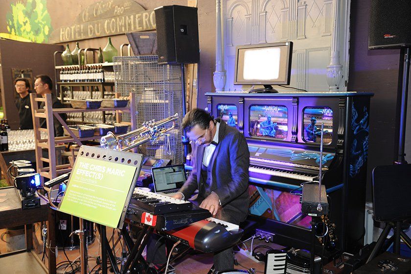 A man in a tuxedo is playing a keyboard in a room.