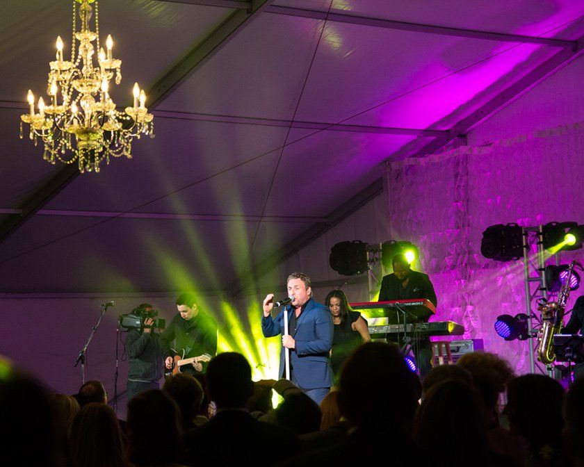 A man singing into a microphone in front of a crowd