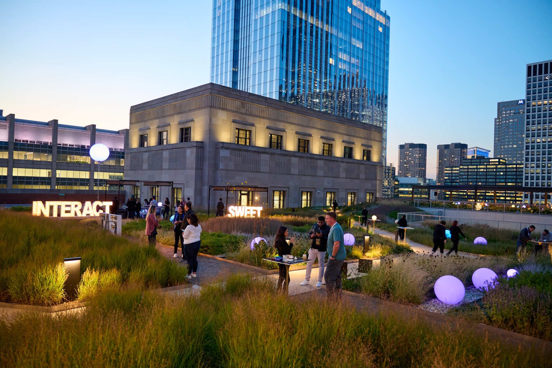A group of people are standing in front of a building that says interact.