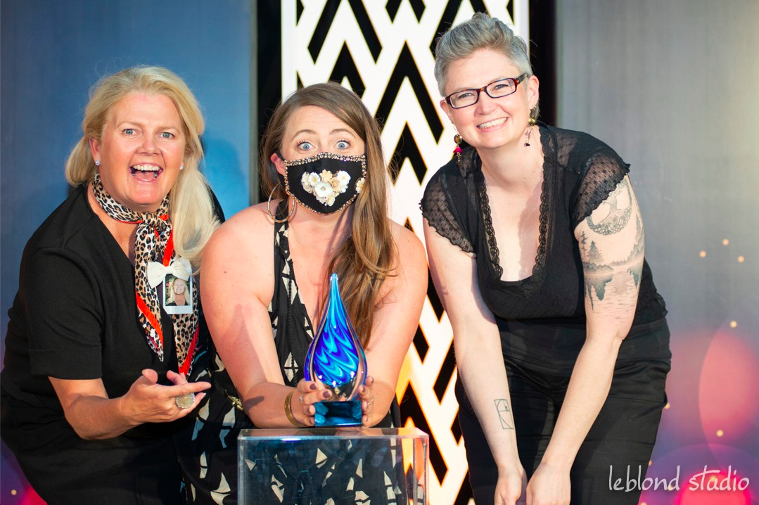 Three women wearing face masks are posing for a picture.