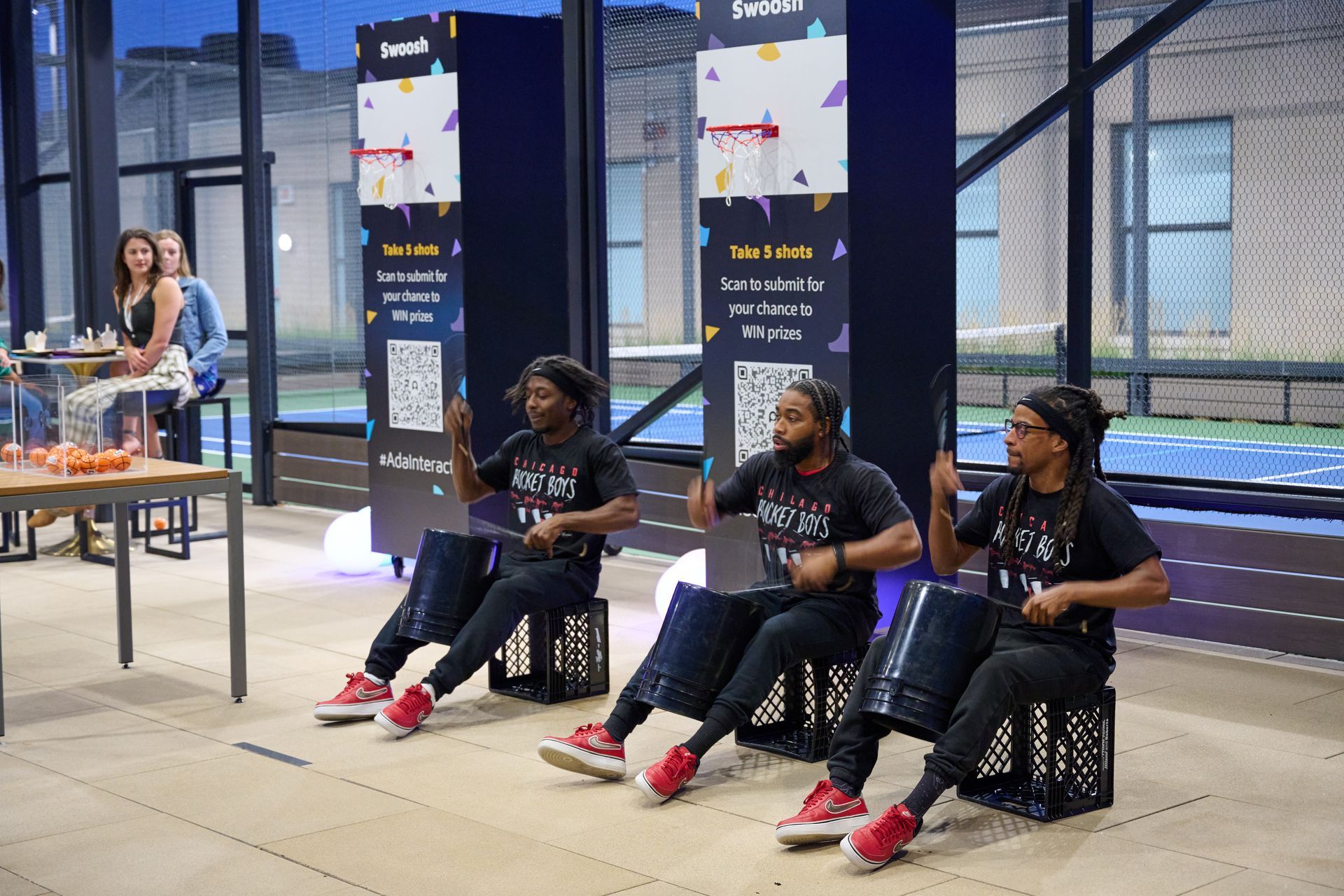 A group of men are sitting on crates playing drums.