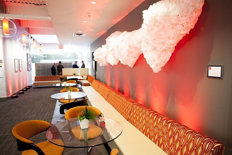 A room with tables and chairs and a red wall