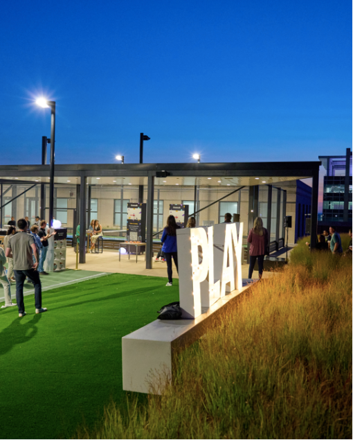 A group of people are standing in front of a sign that says play