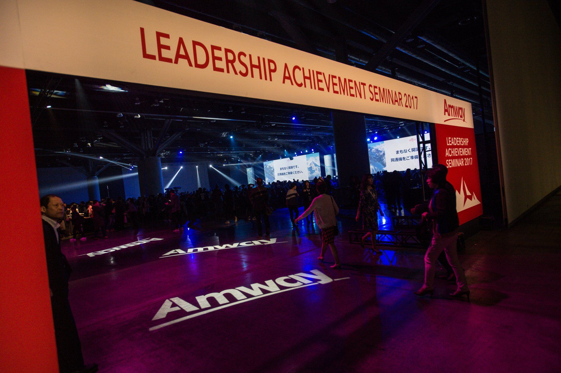 A group of people are standing in front of a sign that says leadership achievement seminar