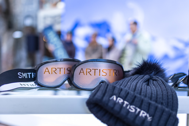 A pair of sunglasses and a hat are on a table.