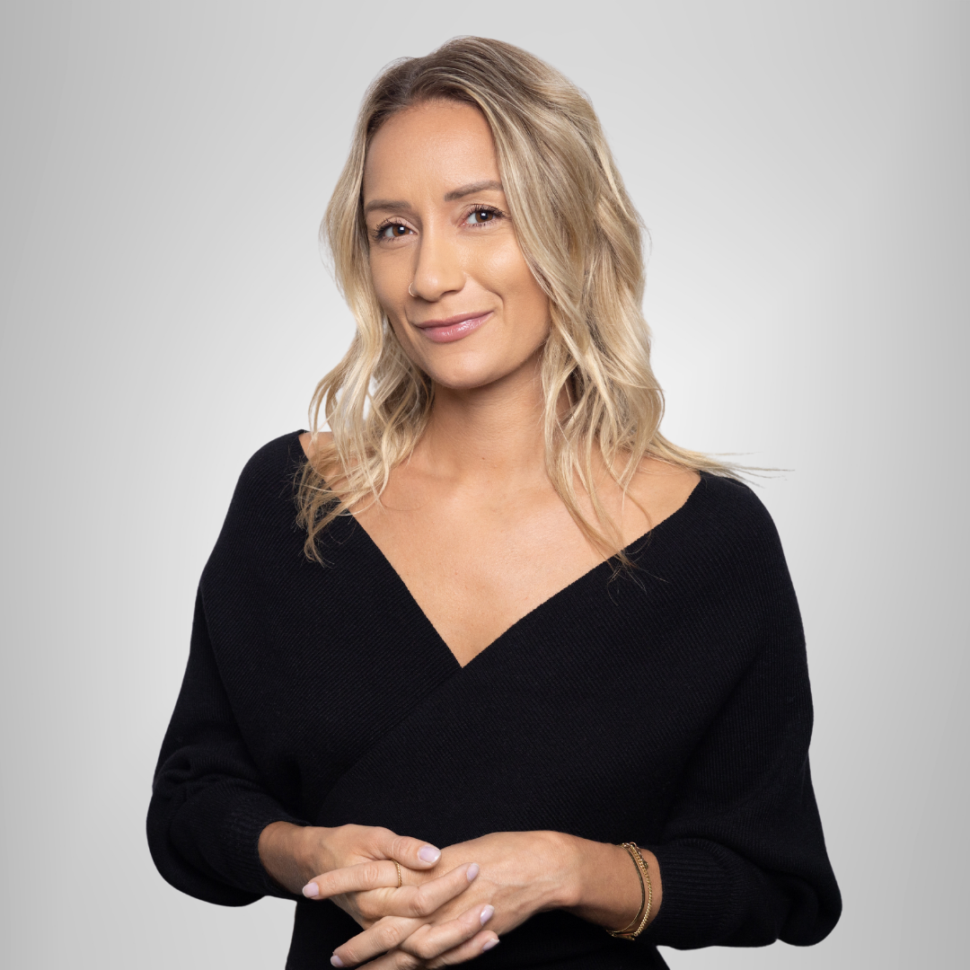 The woman is wearing a black sweater and smiling for the camera.