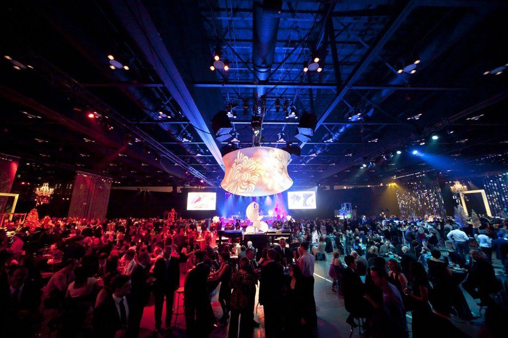 A large crowd of people are watching a concert in a large auditorium.