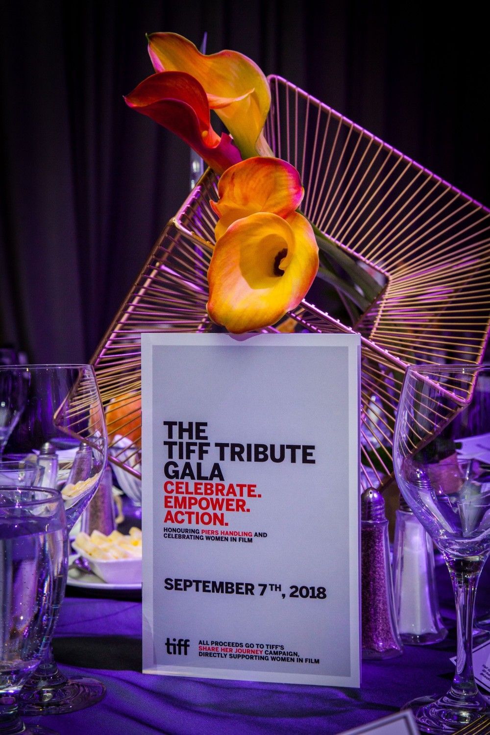A table set for a tiff tribute gala with flowers on it.
