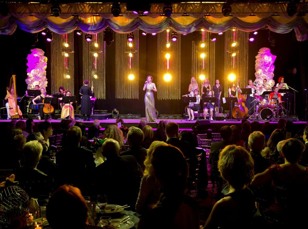 A woman is singing on a stage in front of a crowd of people.