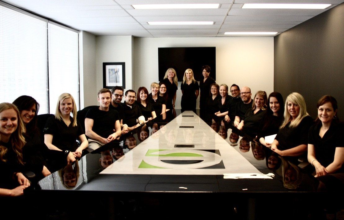 A group of people are posing for a picture in a conference room