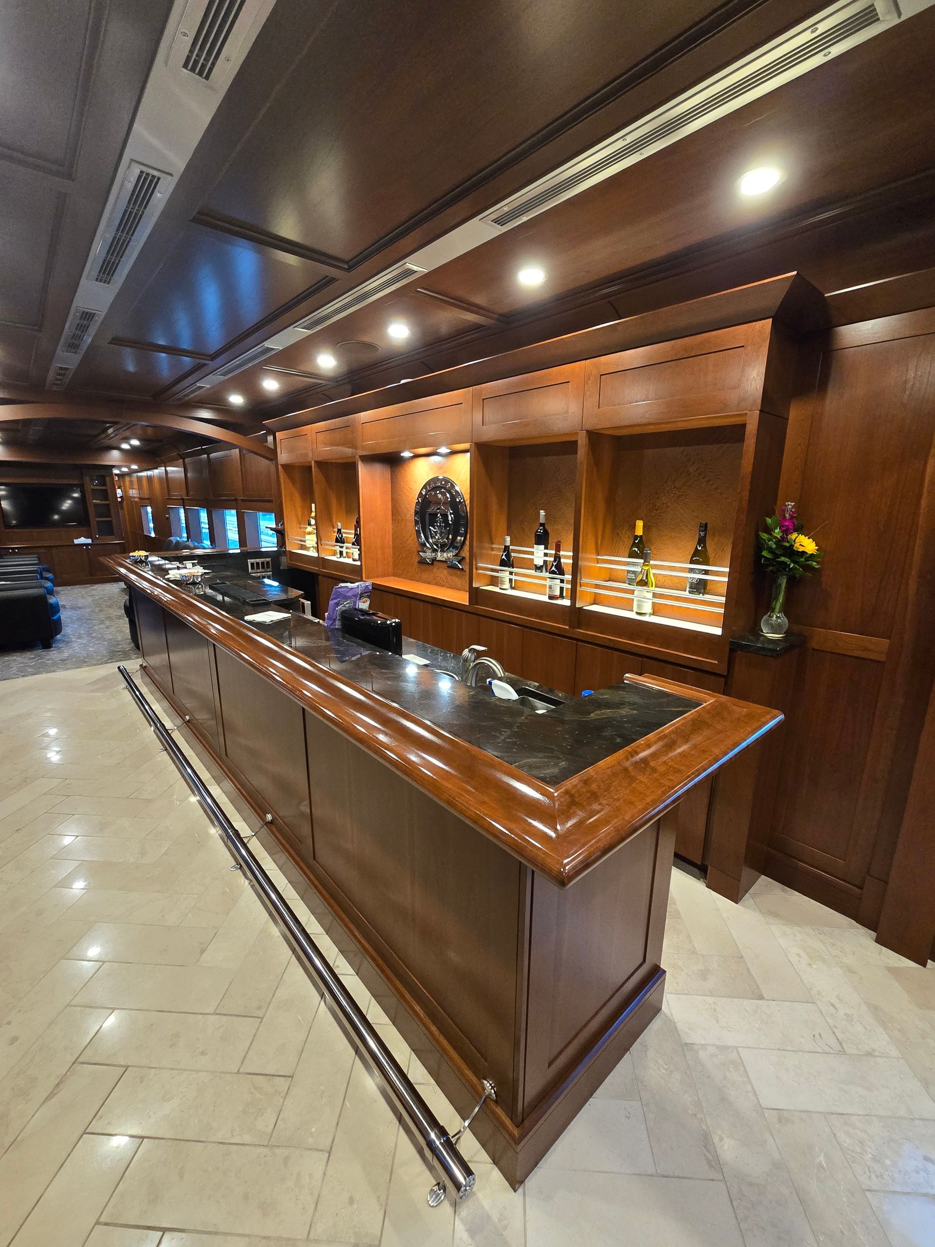 A long wooden bar with a black counter top in a room.