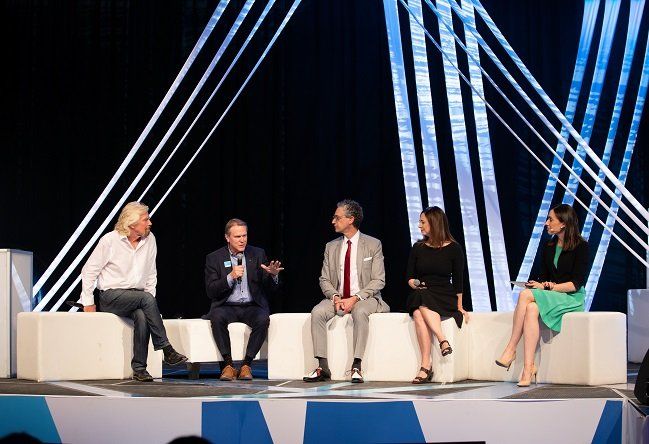 A group of people are sitting on a stage talking to each other.