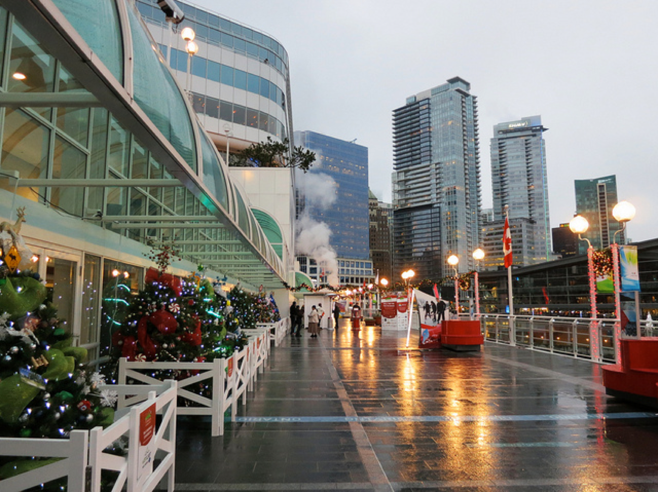 A rainy day in a city with christmas decorations on the sidewalk