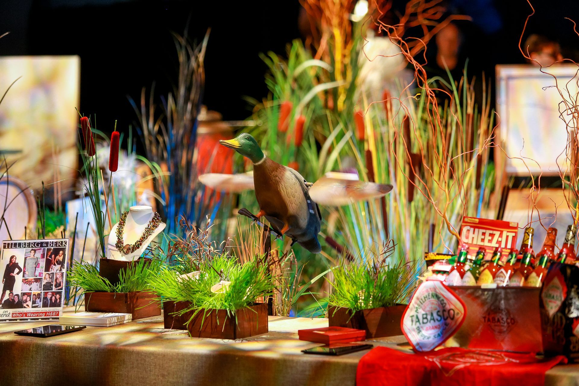 A table with a duck statue and plants on it.