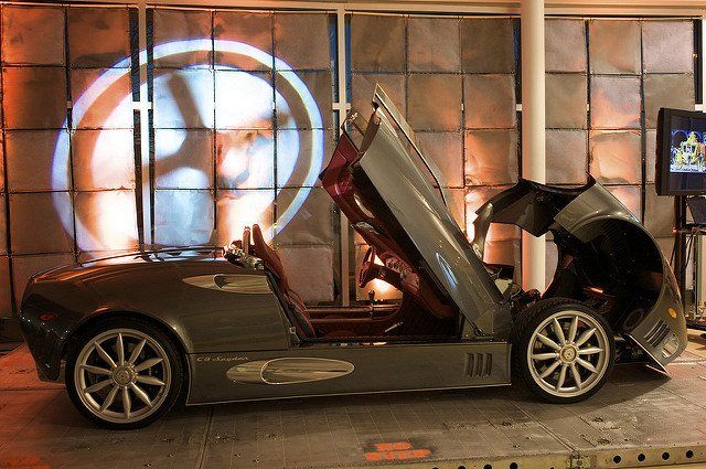 A car is parked in a garage with its doors open