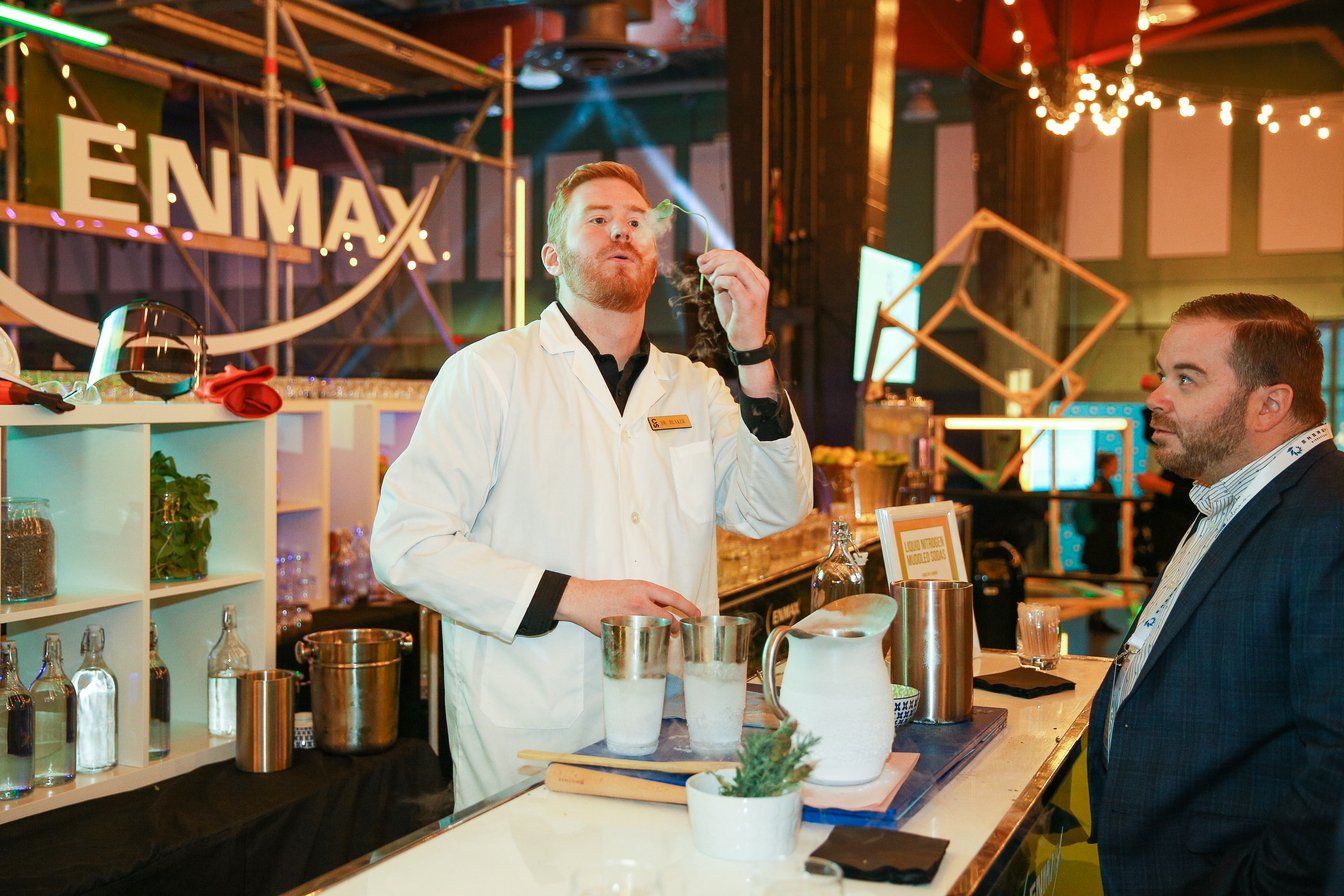 A man in a white coat is standing in front of a sign that says enmax.