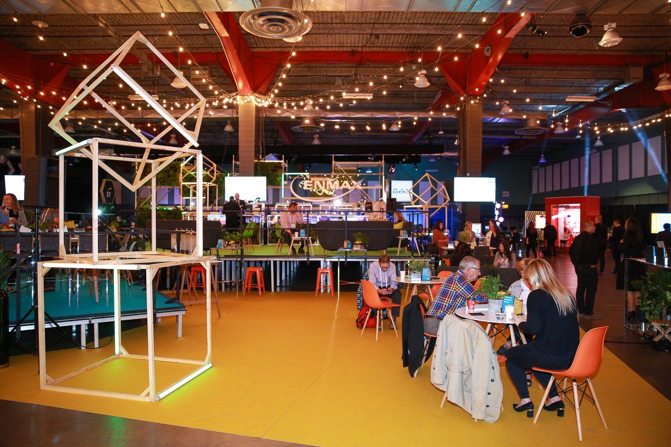 A group of people are sitting at tables in a large room.