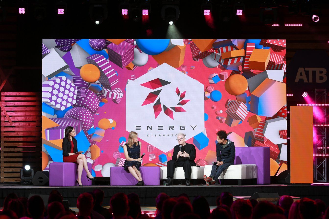 A group of people are sitting in front of a large screen that says energy