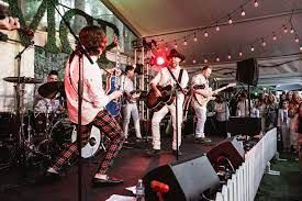 A group of people are standing on a stage playing instruments.