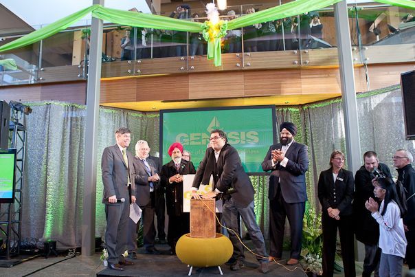 A group of people are standing in front of a screen that says genesis