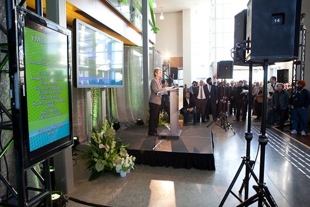 A woman is giving a speech on a stage in front of a crowd.