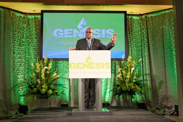 A man is standing at a podium with a sign that says genesis on it.