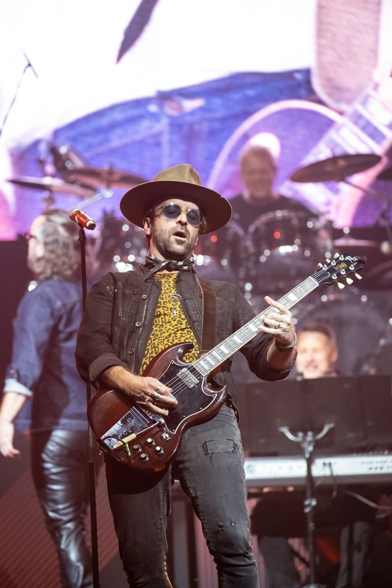 A man is playing a guitar and singing into a microphone on a stage.