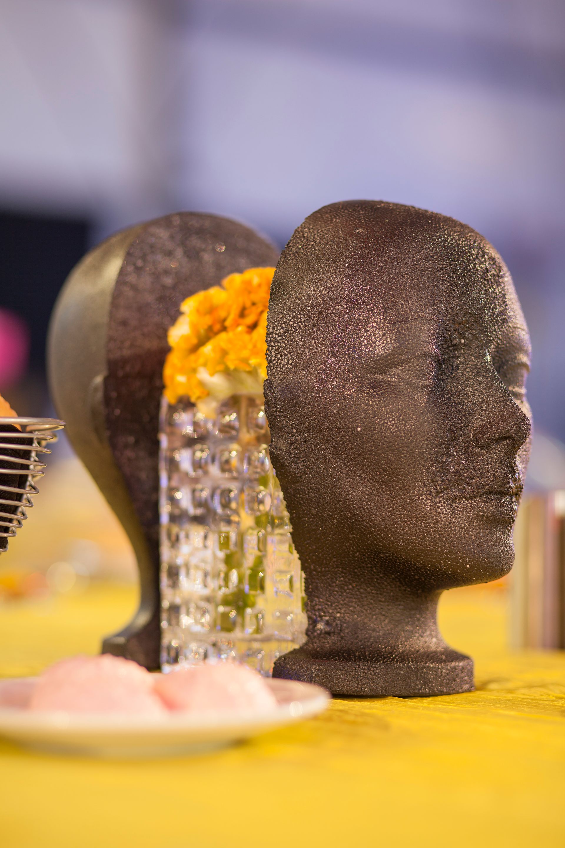 A couple of mannequin heads sitting on top of a table.
