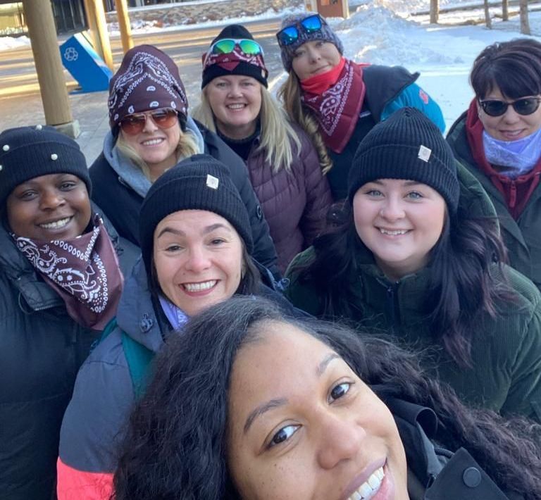 A group of women are posing for a picture in the snow