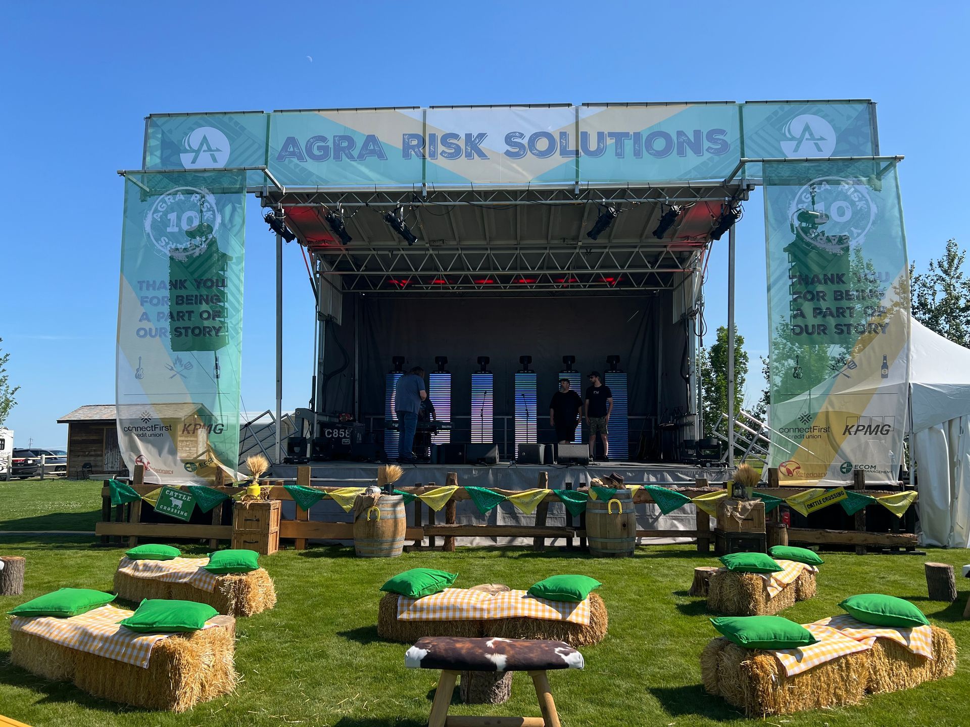 A man in a graduation cap and gown is kneeling down on a stage.