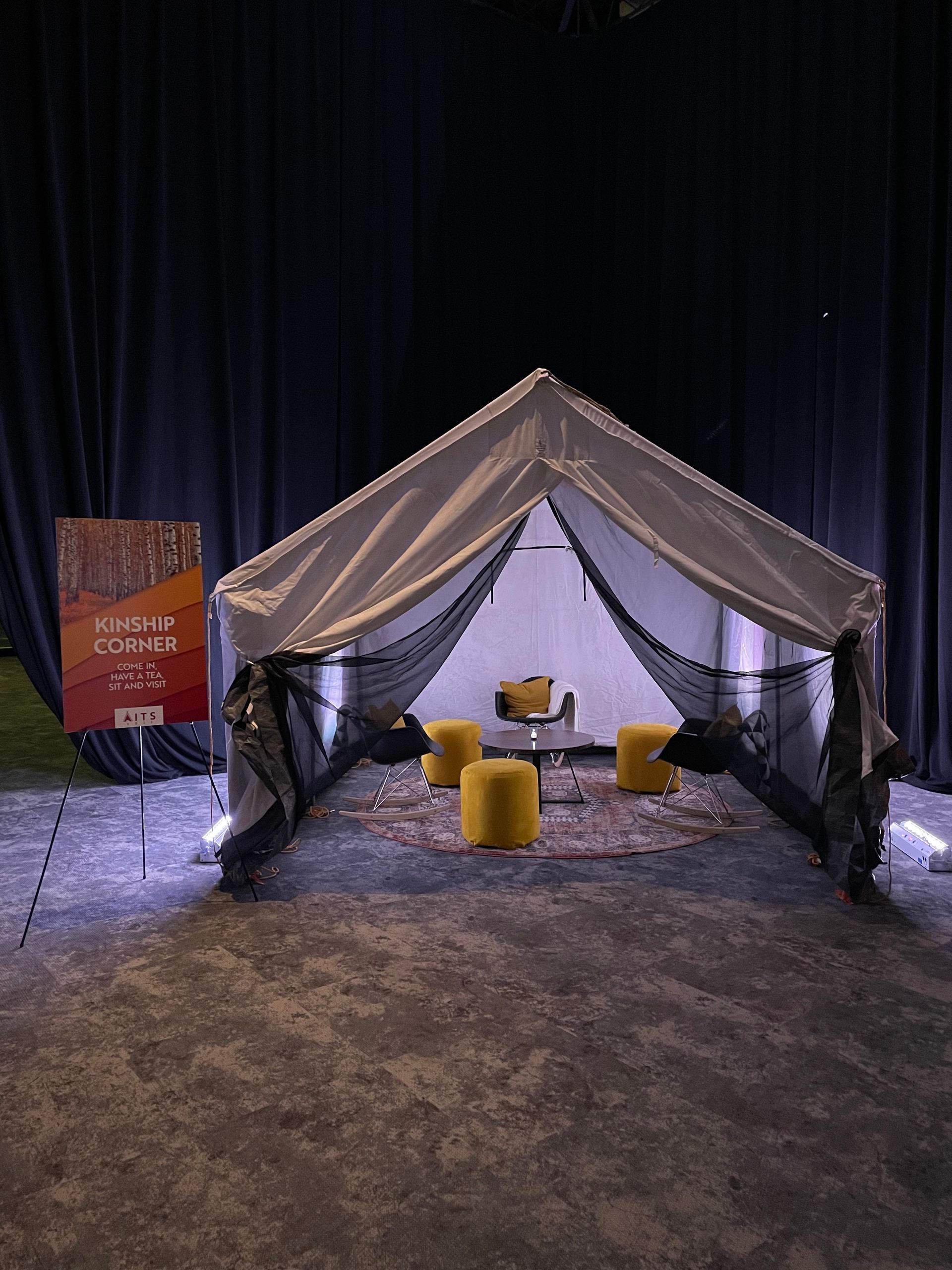 A tent with a table and chairs inside of it.