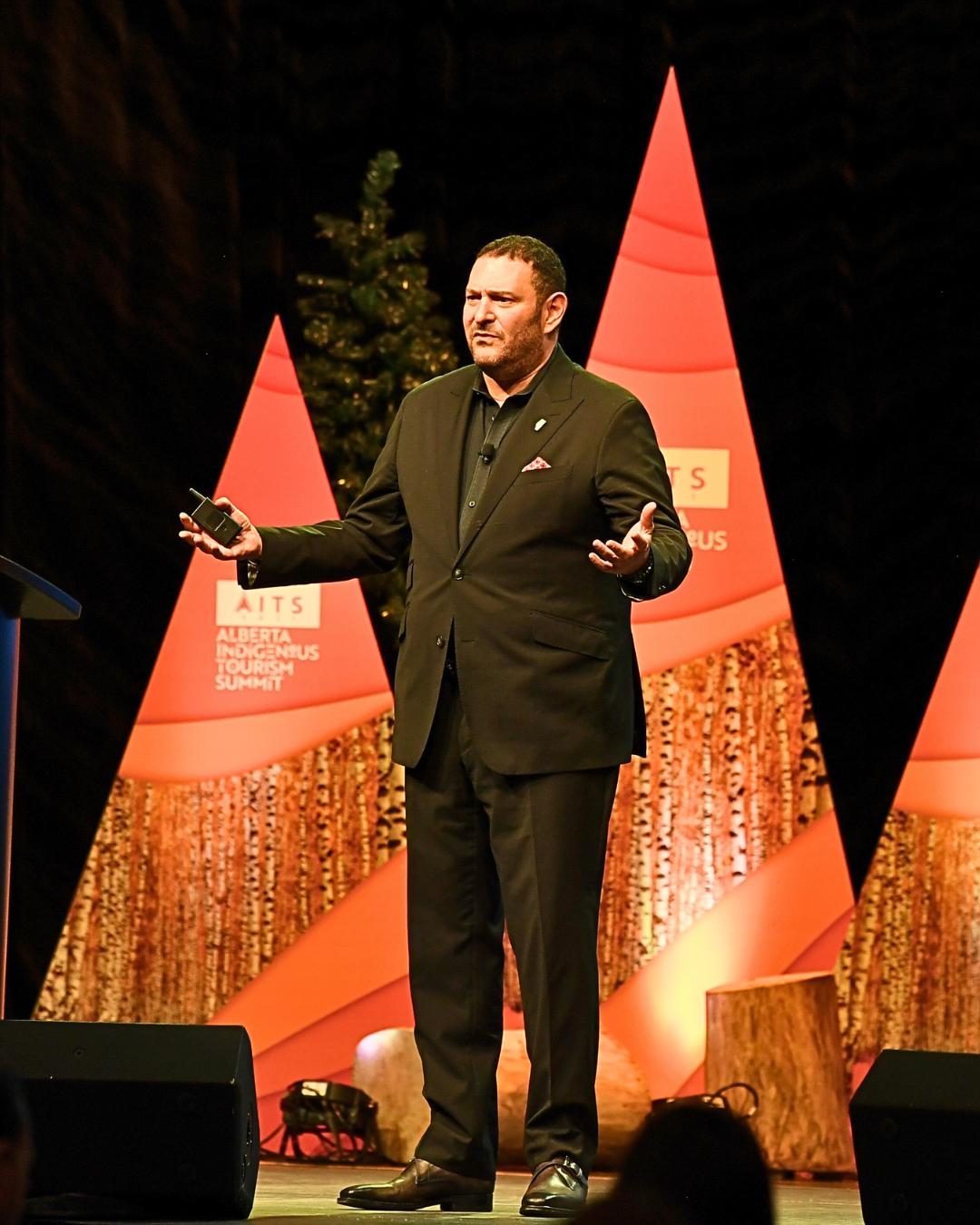 A man in a suit is standing on a stage in front of a podium that says abc