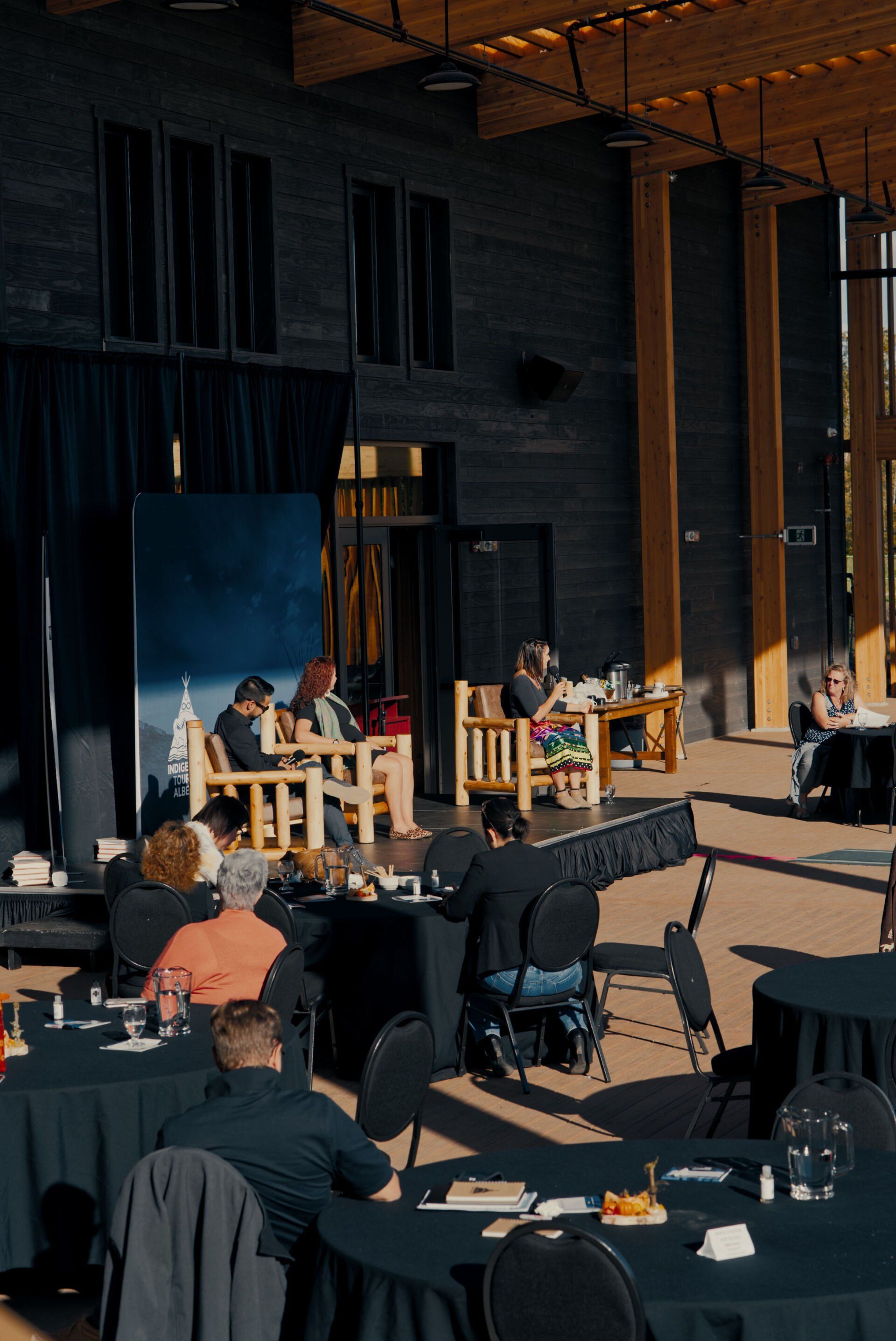 A group of people are sitting at tables in a large room.