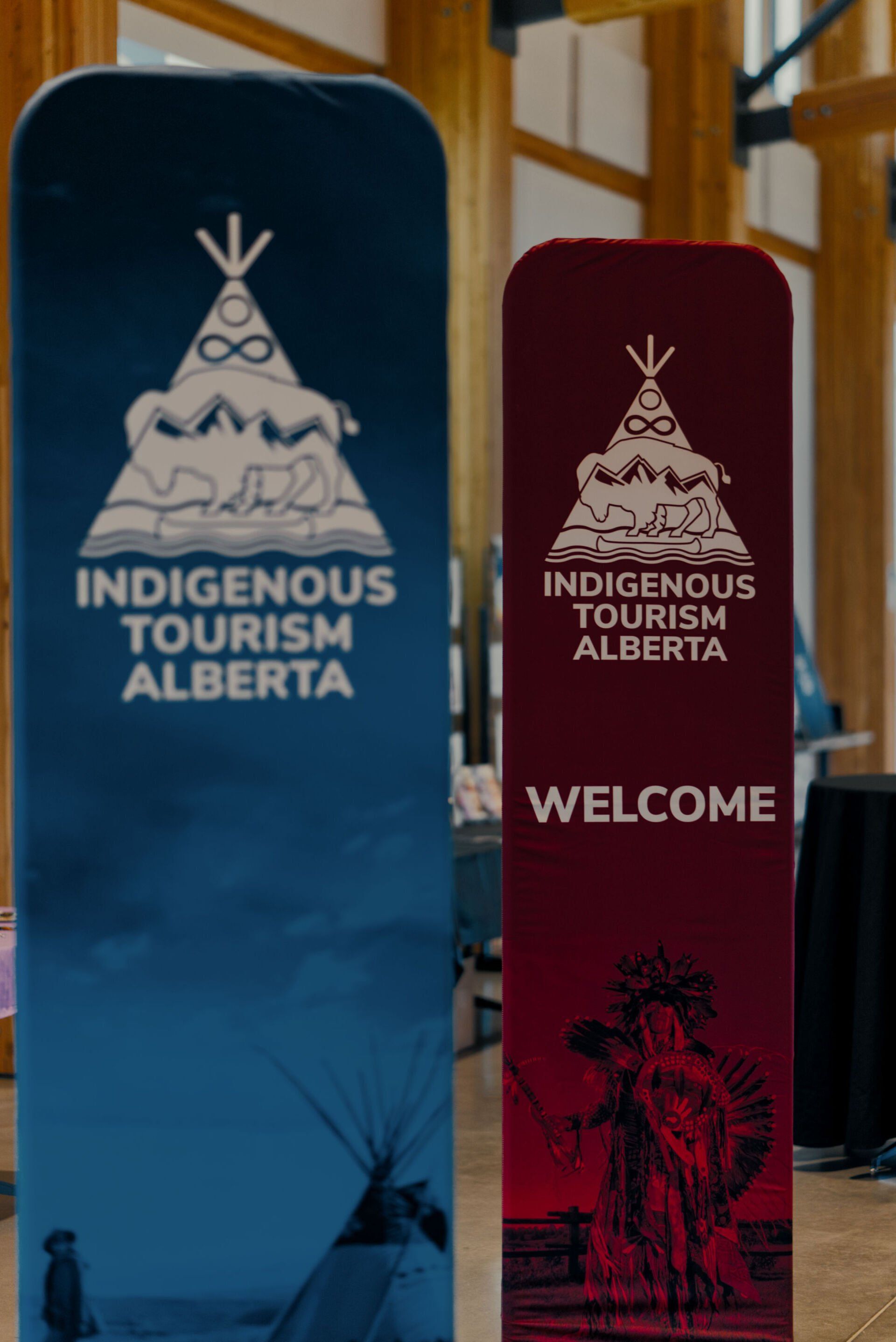 Two signs for indigenous tourism alberta are sitting next to each other