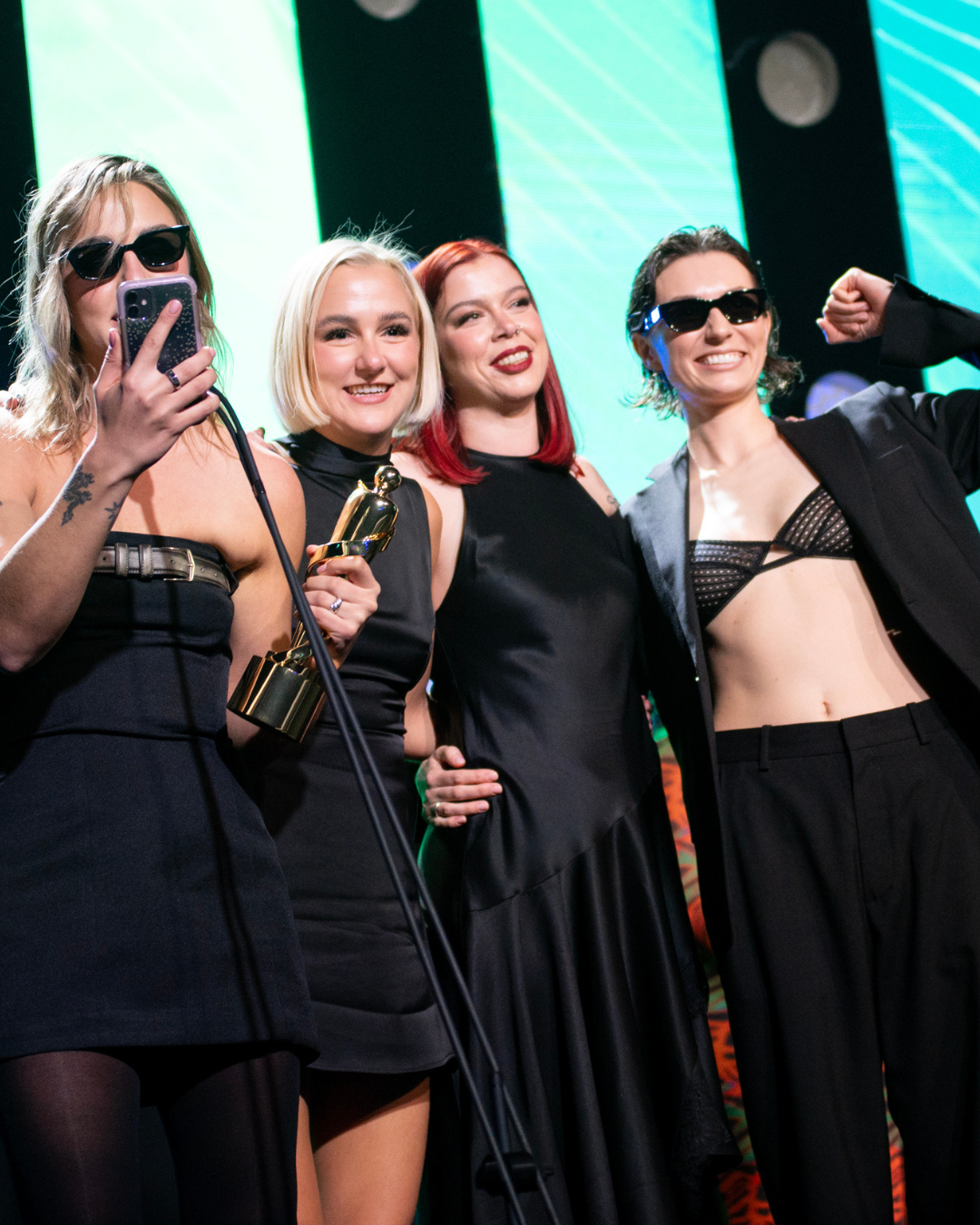 A group of women are posing for a picture on a stage.