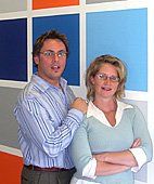 A man and a woman are standing next to each other with their arms crossed.