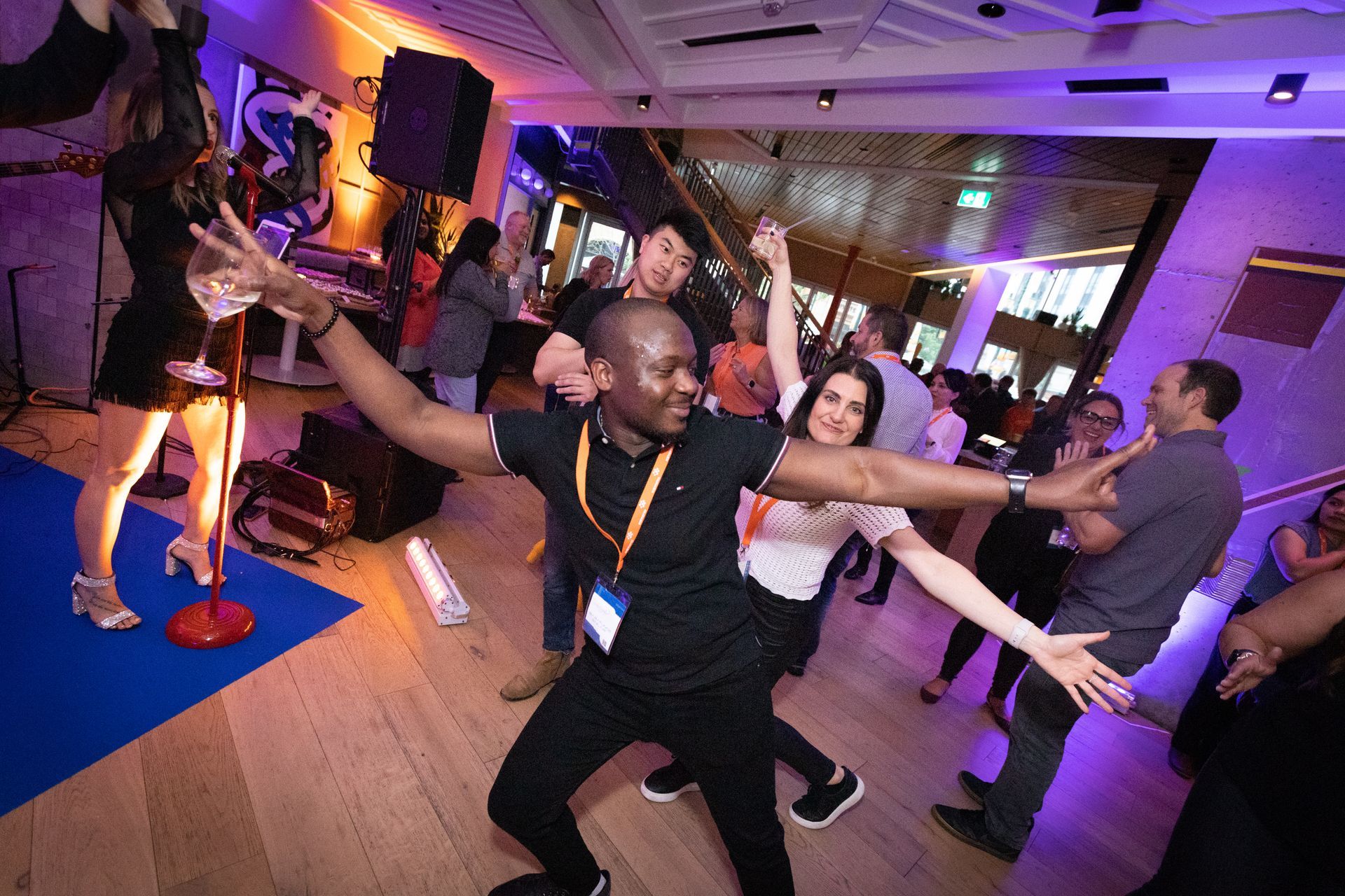 A group of people are dancing on a stage in front of a crowd.