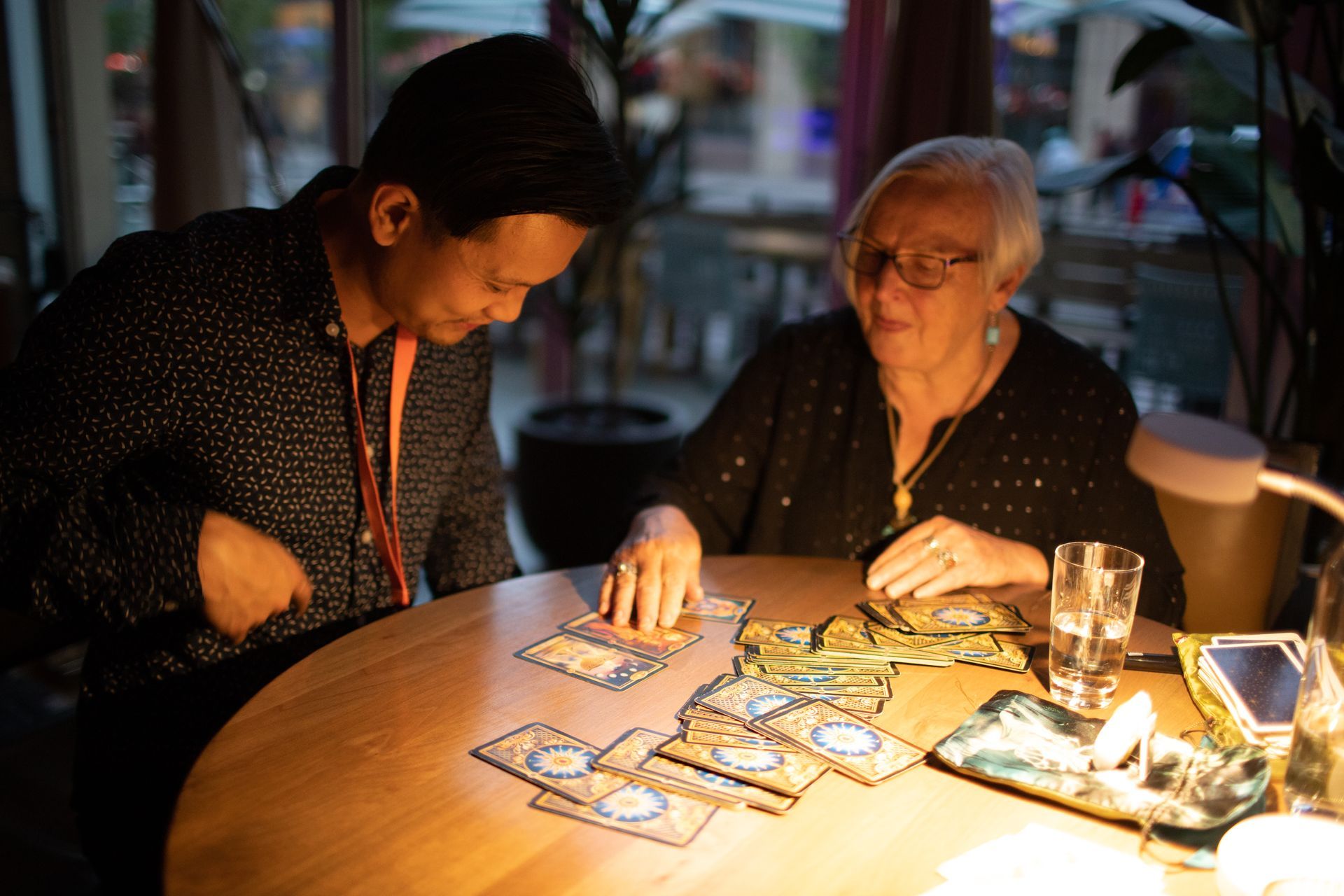 A man and a woman are sitting at a table playing cards.