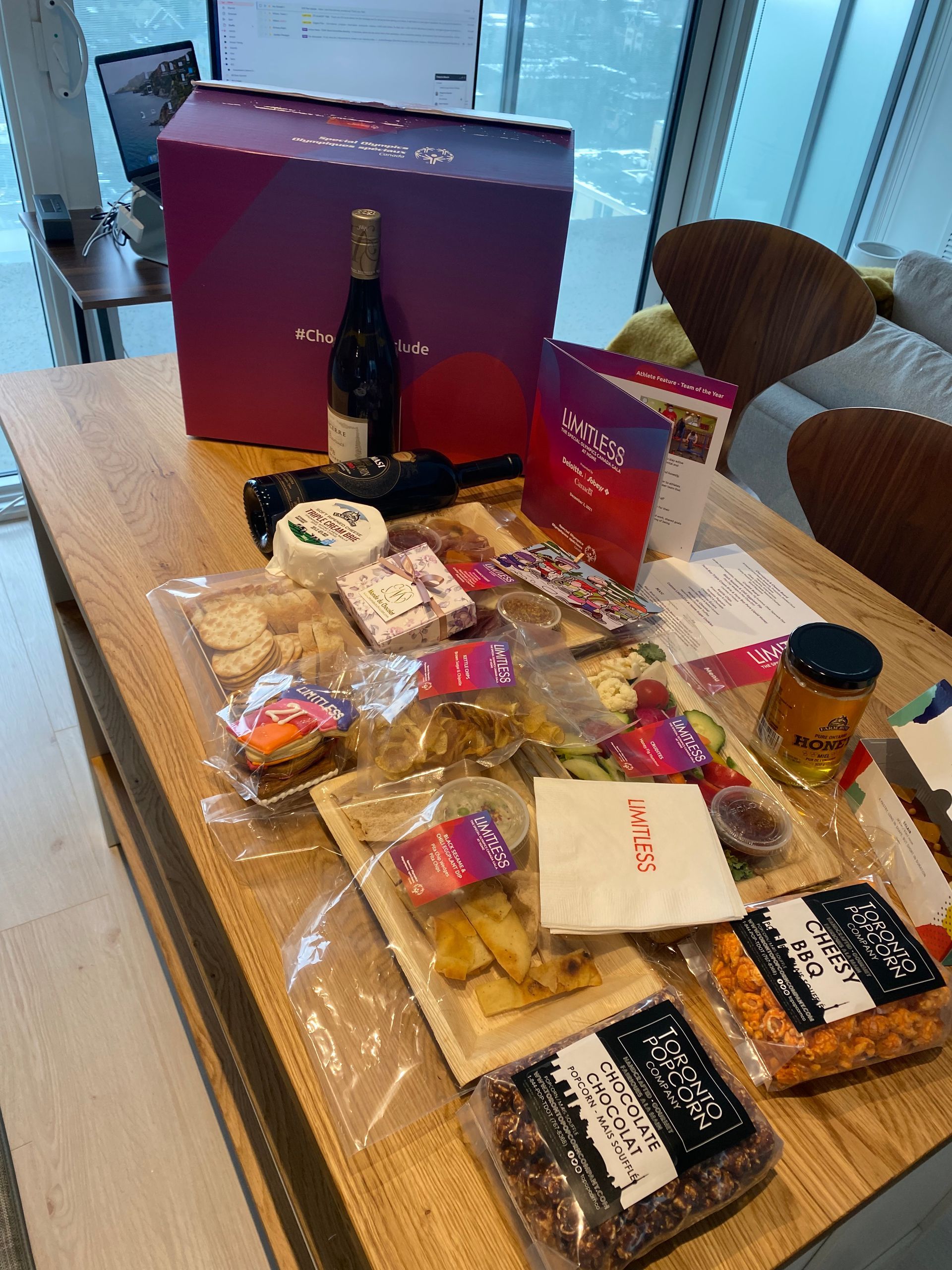 A table topped with a variety of food and a bottle of wine.