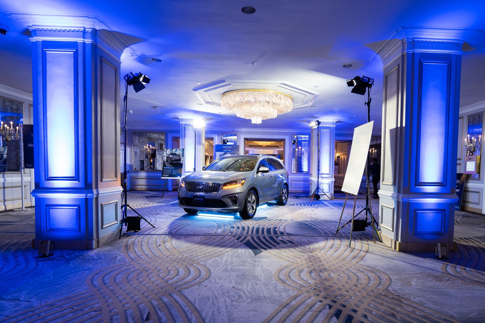 A car is parked in a room with blue lights.