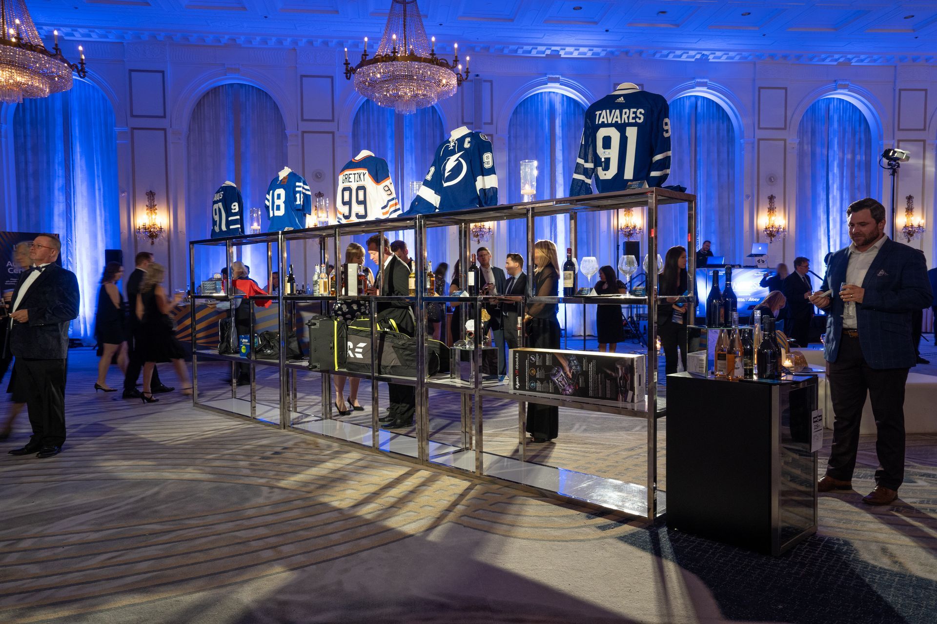 A group of people are standing in a room with jerseys on display.