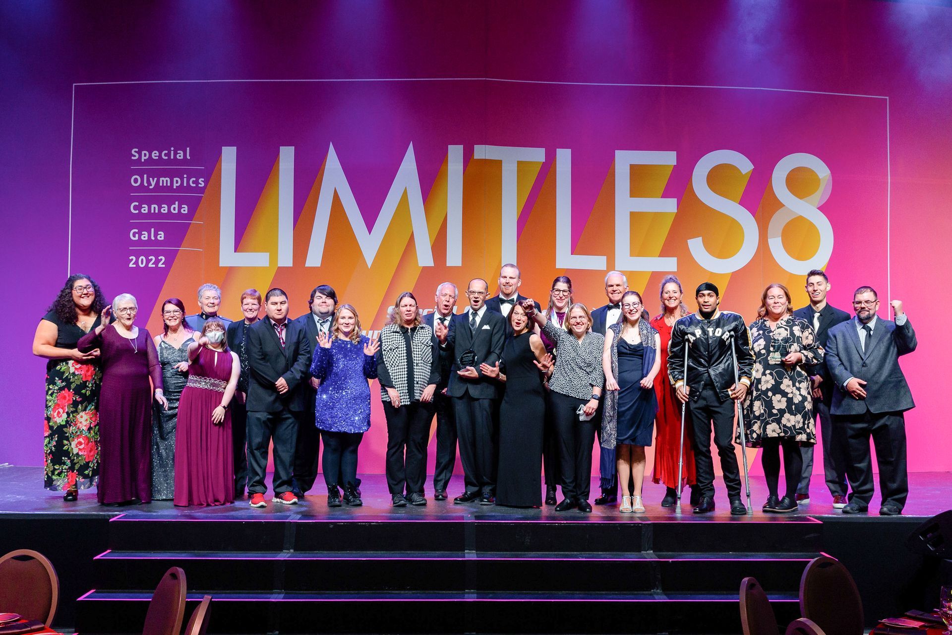 A group of people are standing on a stage in front of a sign that says limitless.