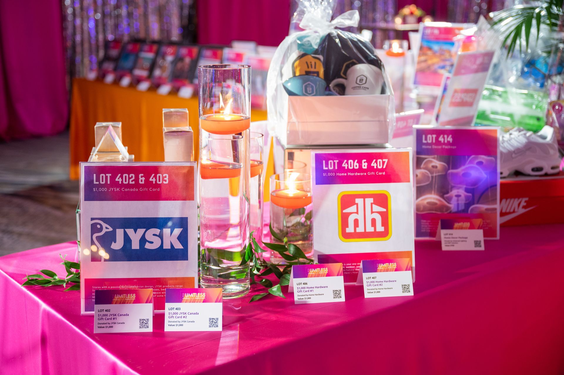 A table with a lot of signs on it and a pink table cloth.