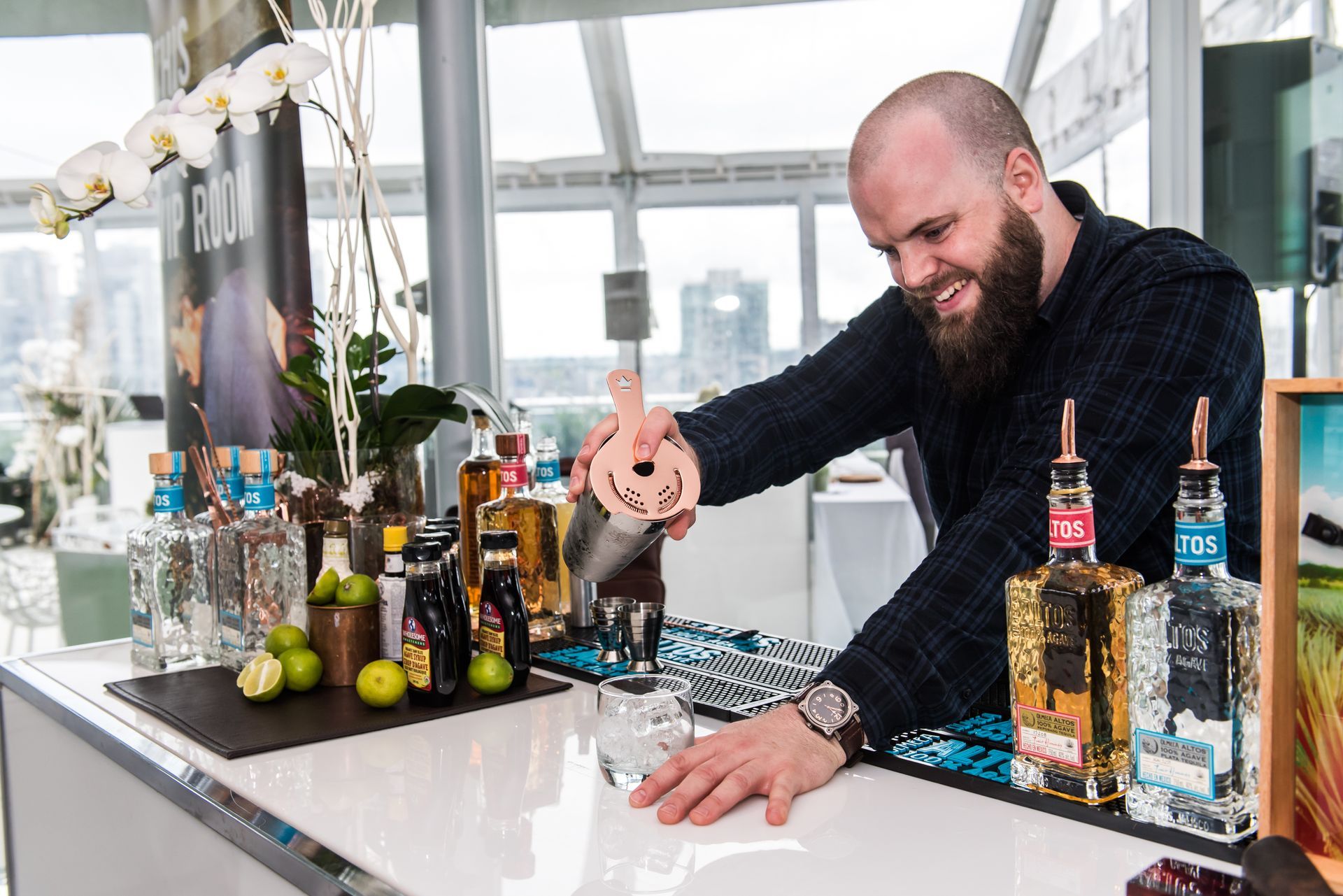 A man with a beard is making a drink at a bar.